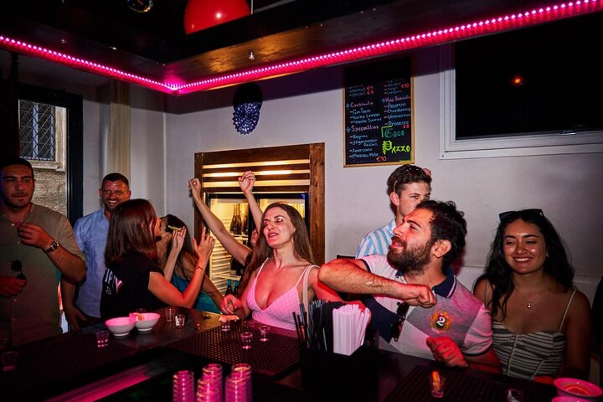 en gruppe mennesker som sitter i en bar med hendene i været