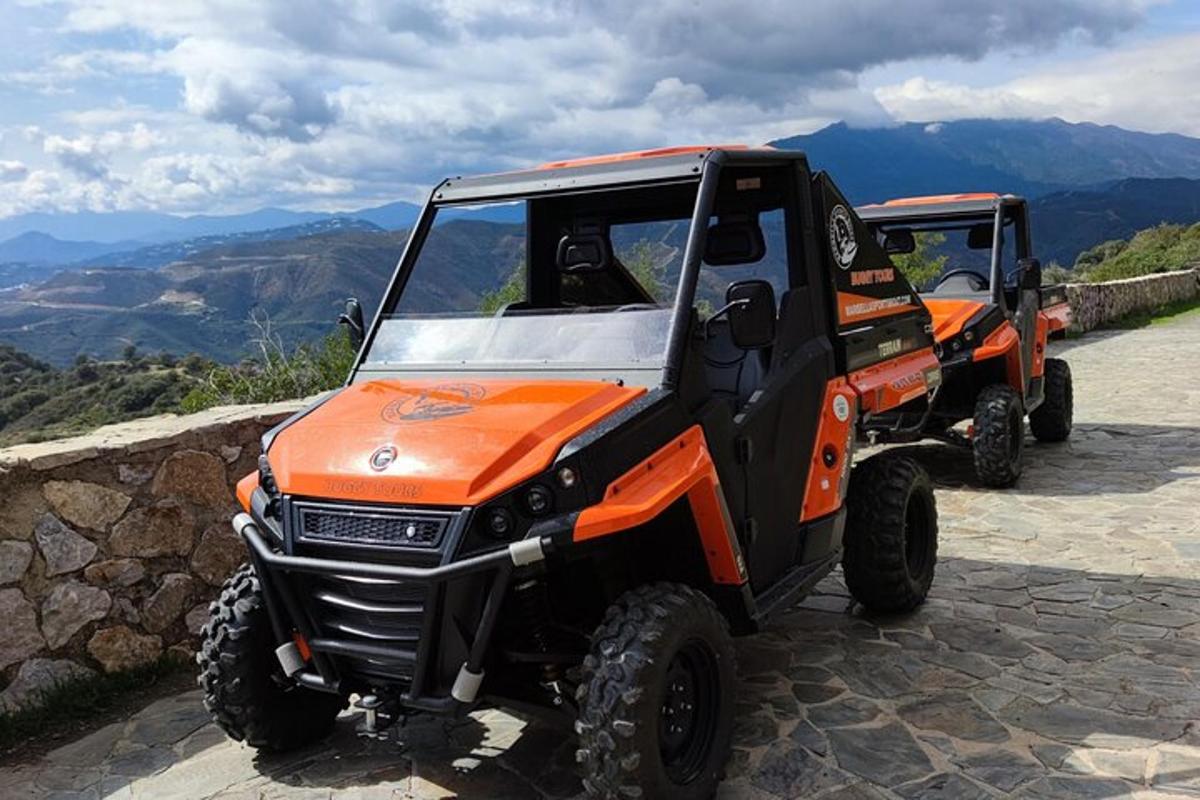 to oransje og svarte ATV-er parkert på toppen av et fjell