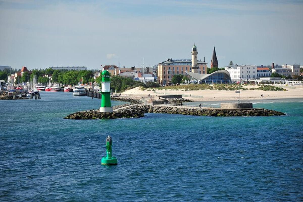 a green lighthouse in the middle of a body of water