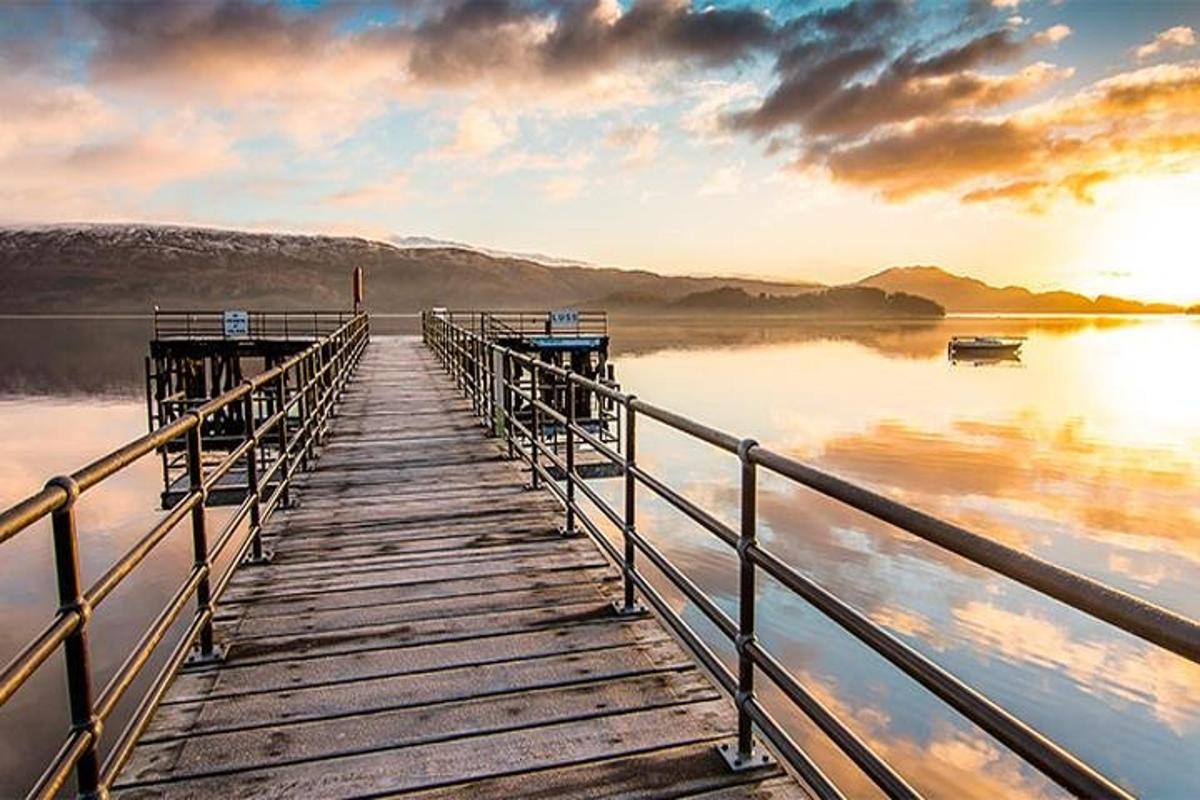 bryggja við vatn við sólsetur