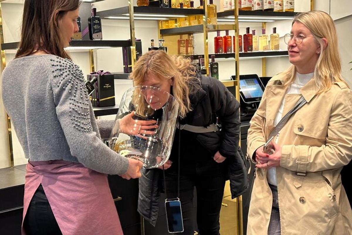 tři ženy stojící v obchodě a držící sklenice vína