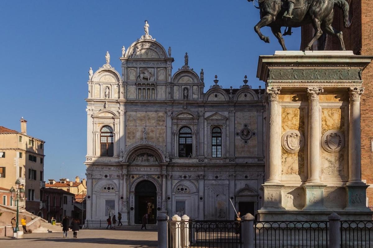 un gran edifici amb una estàtua al davant