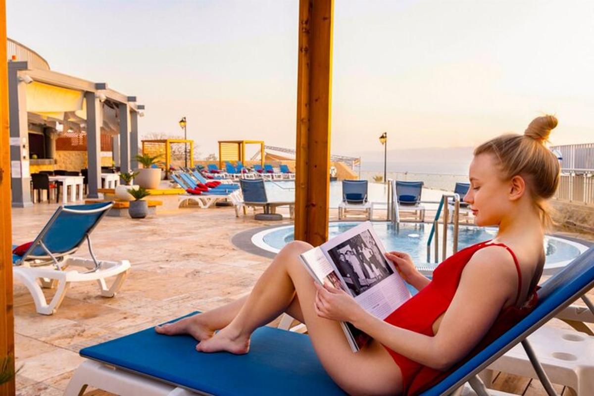 a woman sitting on a beach chair reading a book