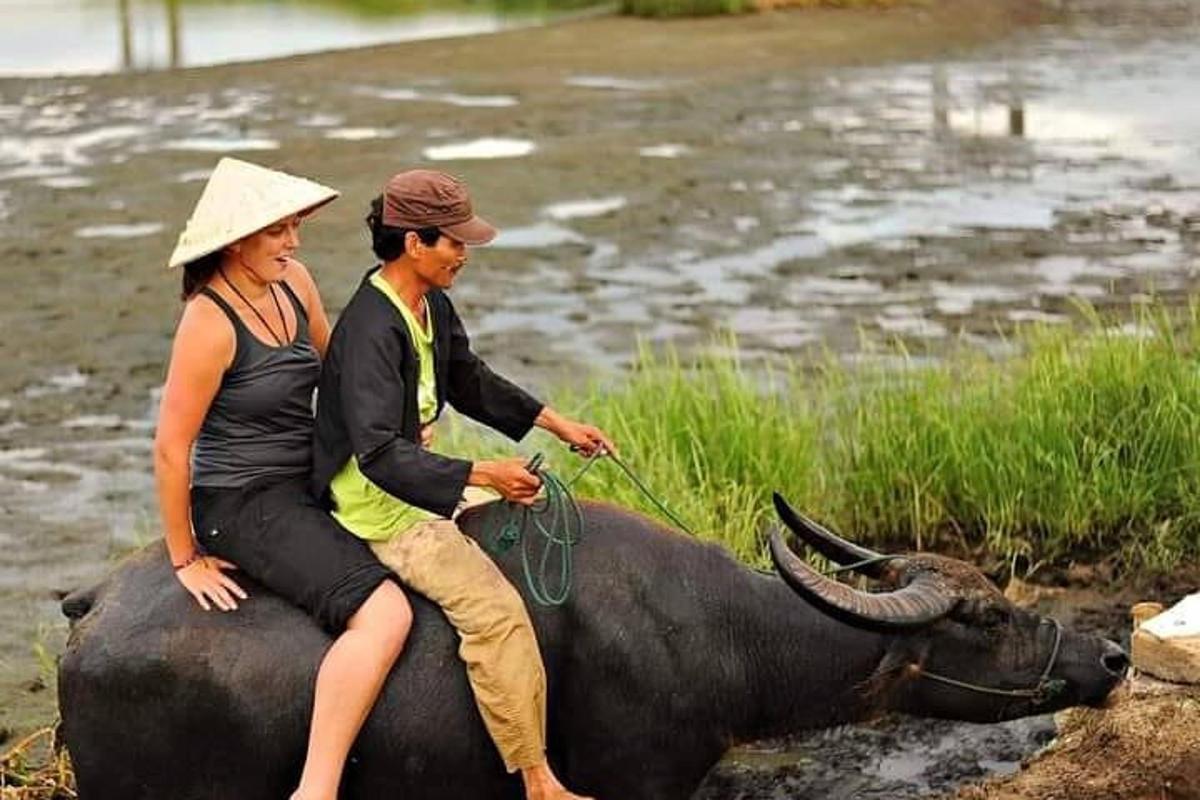 a man and a woman riding on the back of a cow