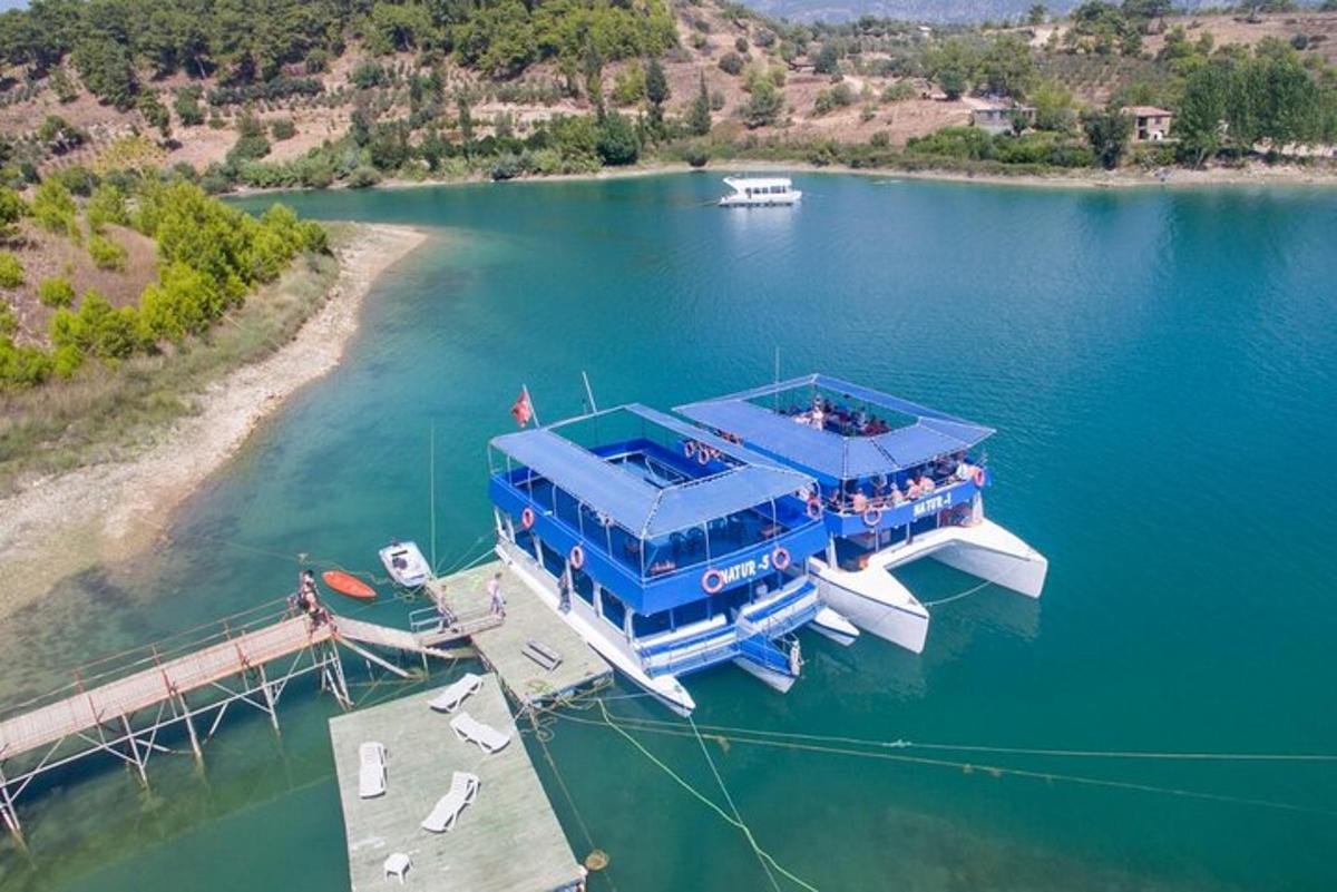 un gran vaixell blau atracat a un moll d'un llac