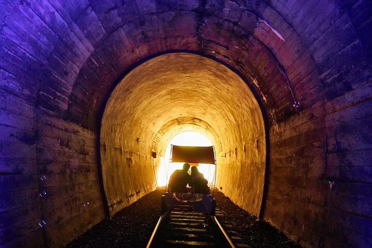 dva lidé sedící na lavičce v tunelu