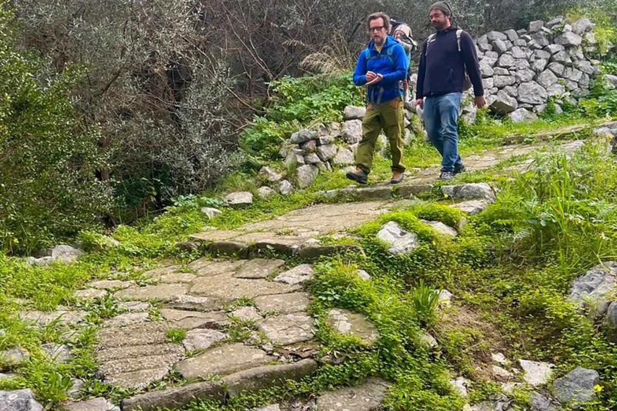due uomini che camminano lungo un sentiero di pietra su una montagna