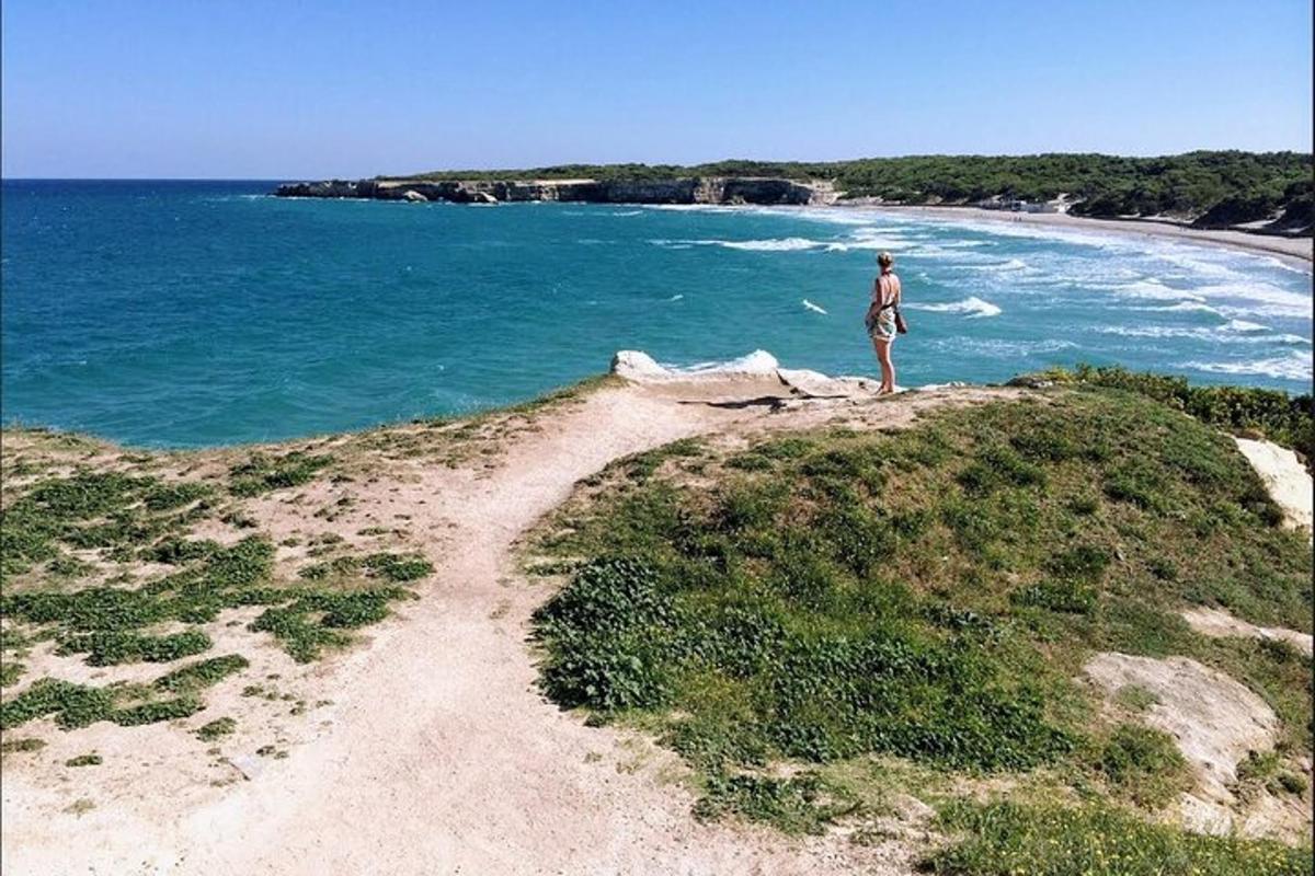Un hombre parado en la cima de una colina cerca del océano.