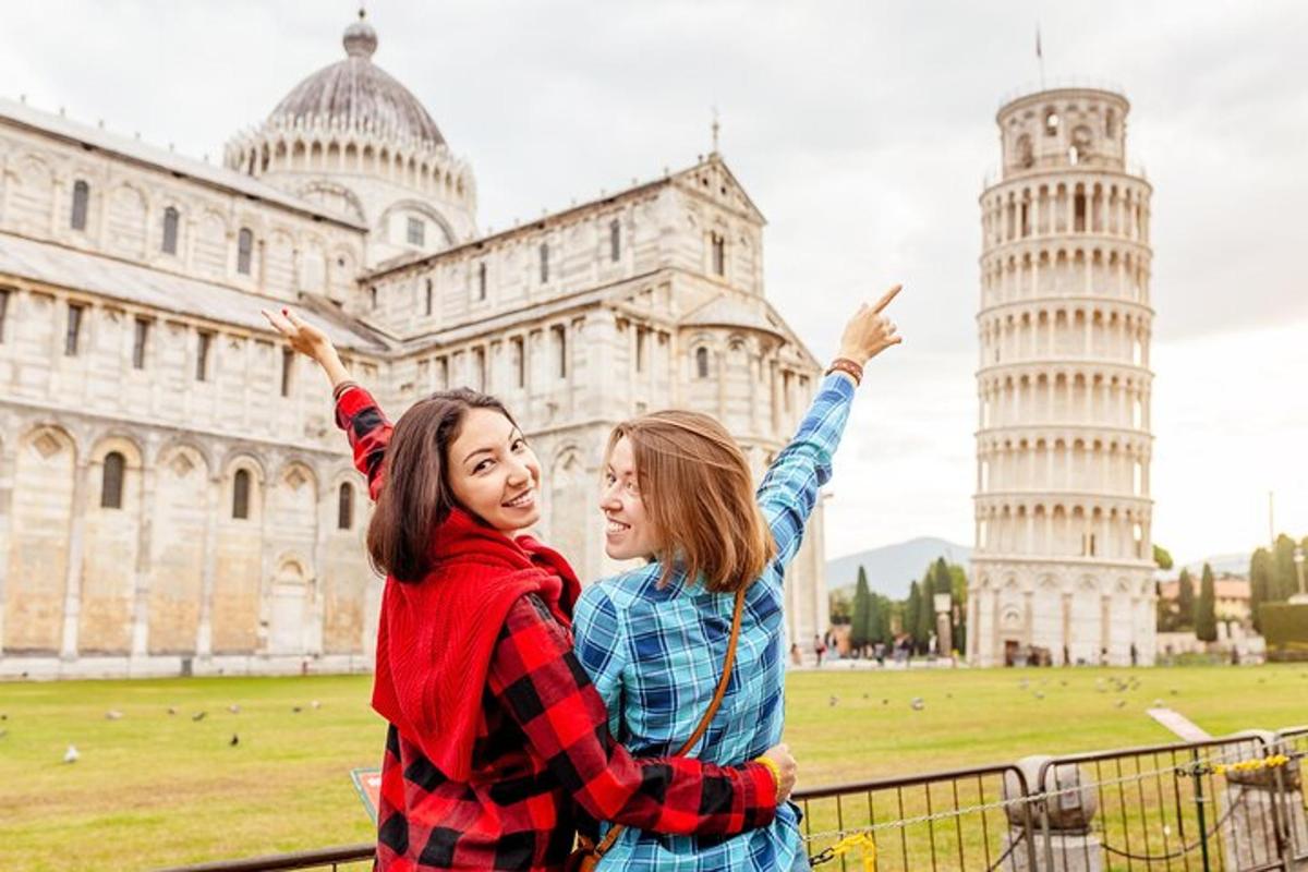 dua wanita berdiri di hadapan menara pisa yang condong