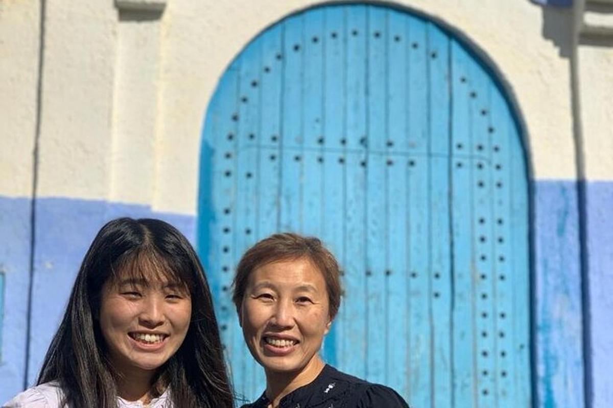 dua wanita berdiri di hadapan pintu biru