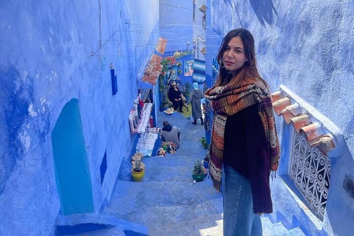 seorang wanita berdiri di atas tangga di bangunan biru