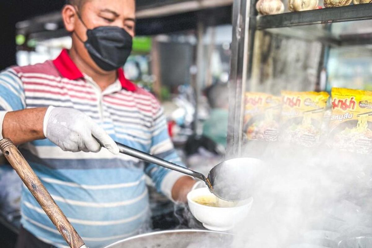 a man wearing a mask cooking food in a pot