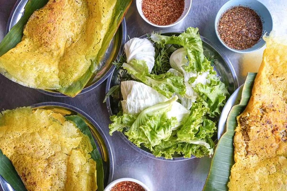 a table with plates of food with lettuce and other foods