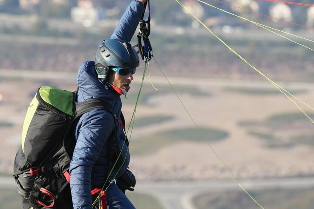 a man is holding on to a parachute