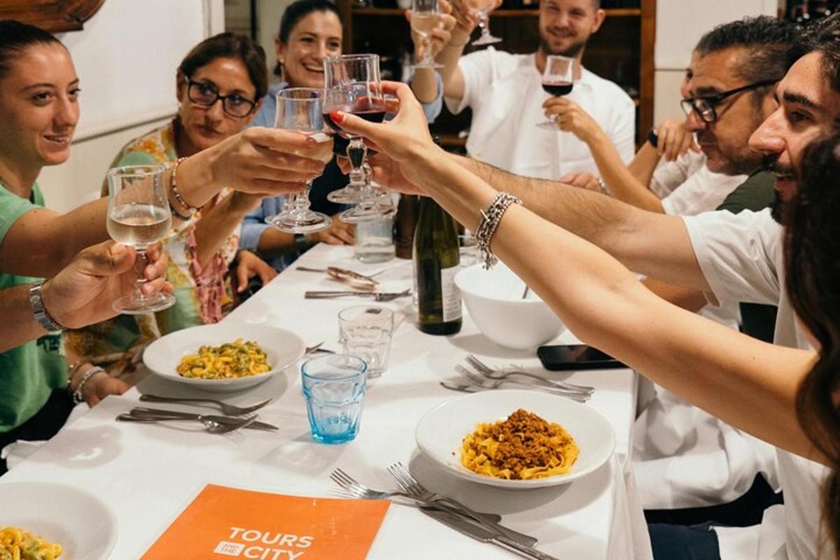 Un grupo de personas sentadas alrededor de una mesa bebiendo vino.