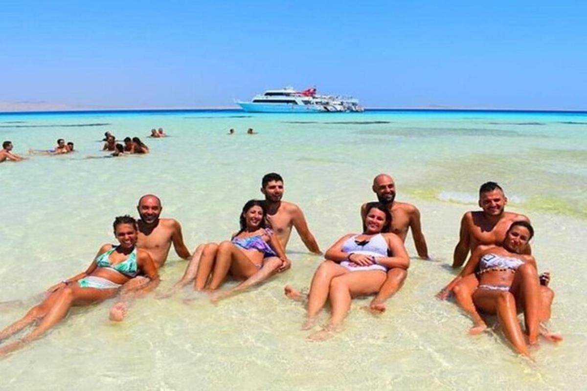 Un grupo de personas sentadas en la arena de una playa