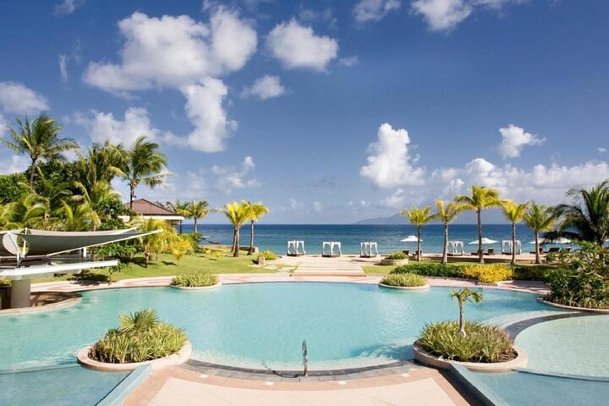 a resort swimming pool with the ocean in the background