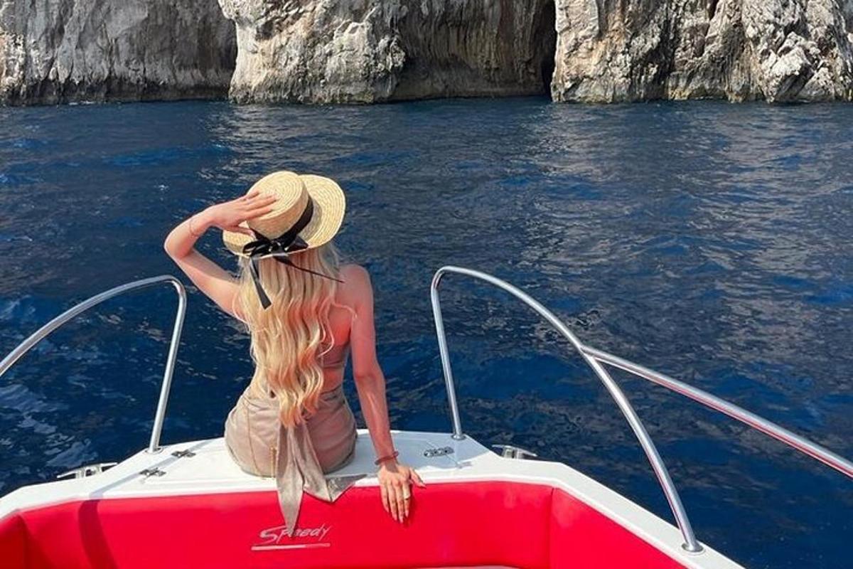 μια γυναίκα με καπέλο που κάθεται στο μπροστινό μέρος μιας βάρκας