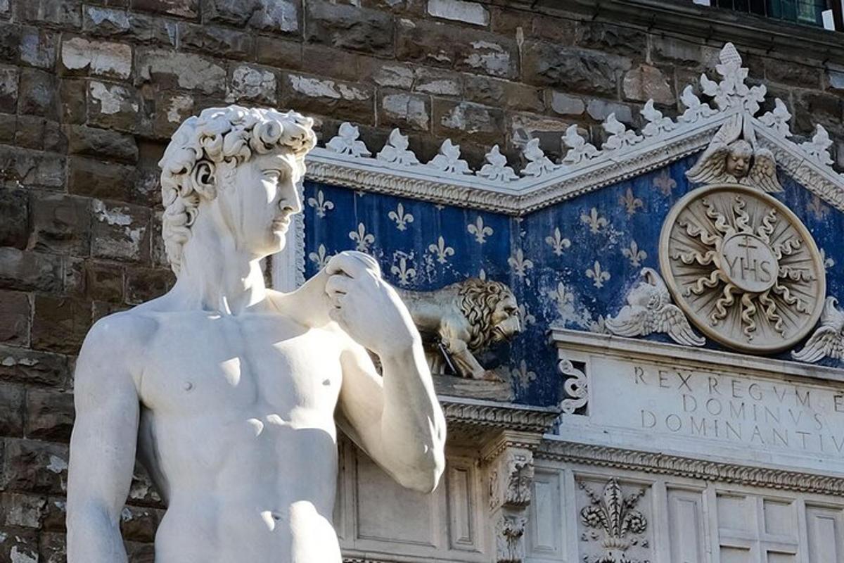 una statua di fronte a un edificio con un orologio