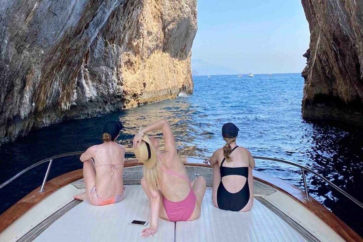 tres personas sentadas en un bote en el agua