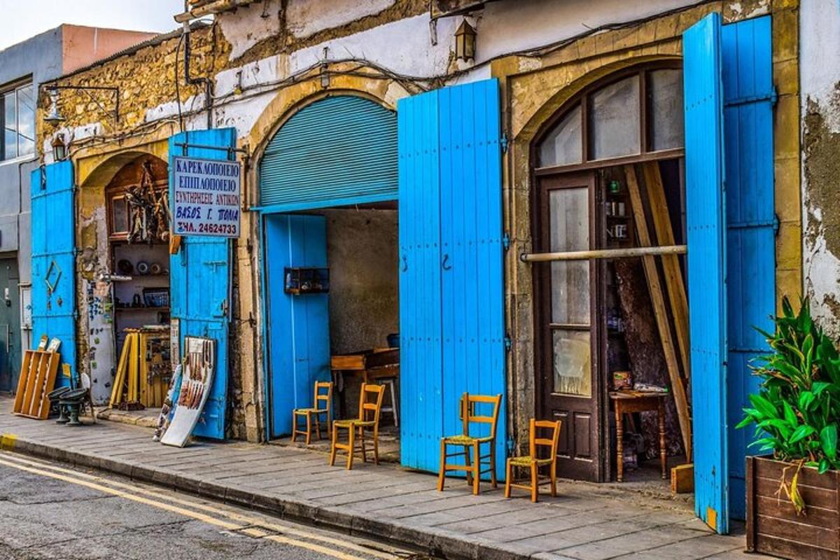 a building with blue doors and chairs on a street