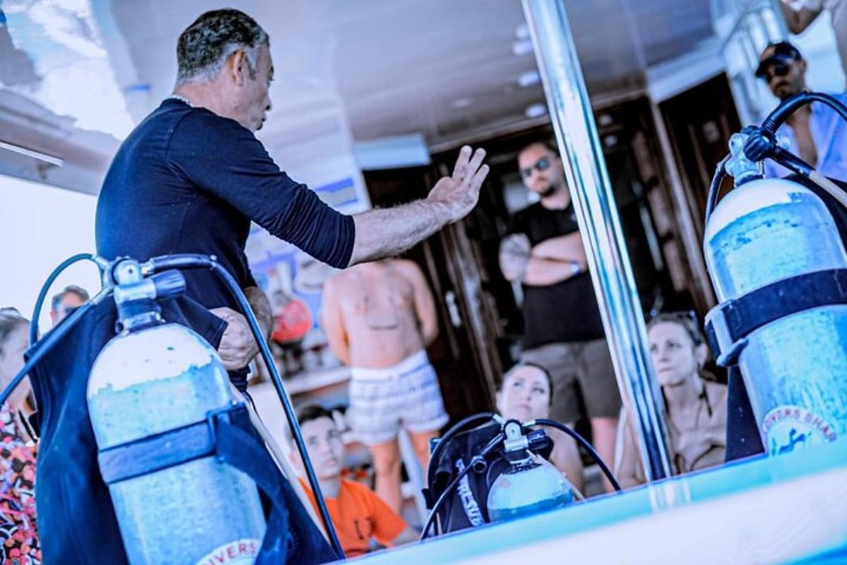 um homem em pé em um barco com um grupo de pessoas