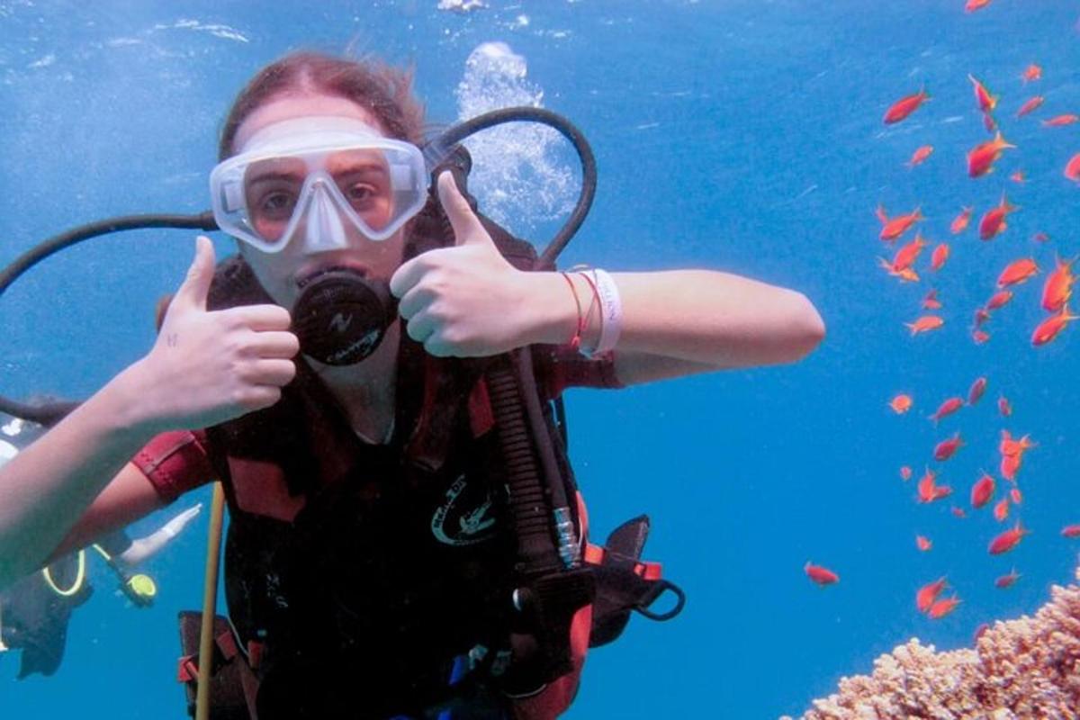 una persona che fa il gesto del pollice in su mentre è sott'acqua