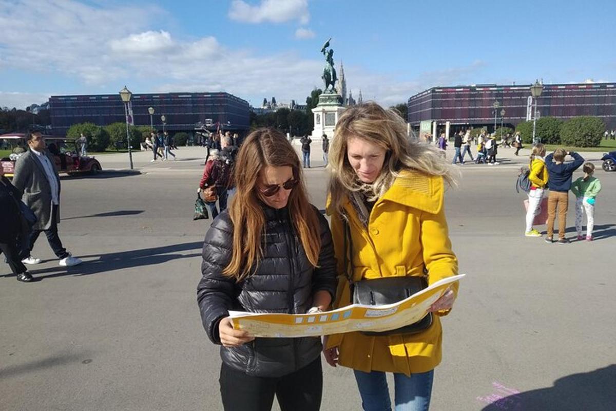 Dvě ženy se dívají na mapu ve městě