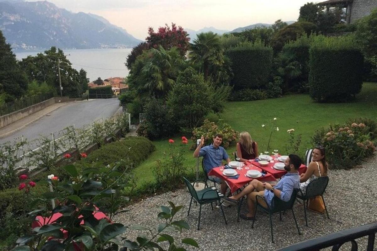 eine Gruppe von Menschen sitzt um einen Tisch in einem Garten