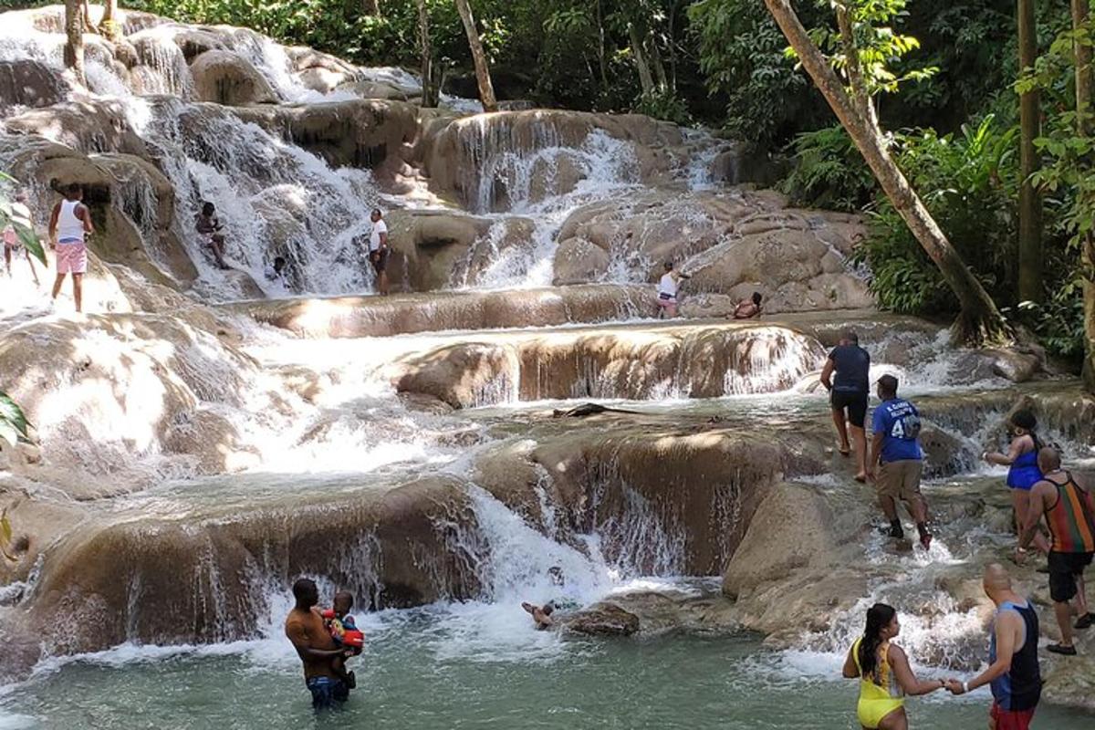 sekumpulan orang berdiri di dalam air terjun