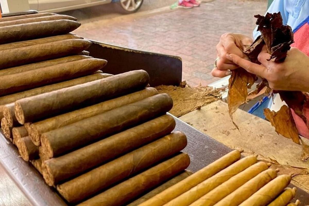 una persona preparant un munt de frankfurts a la graella