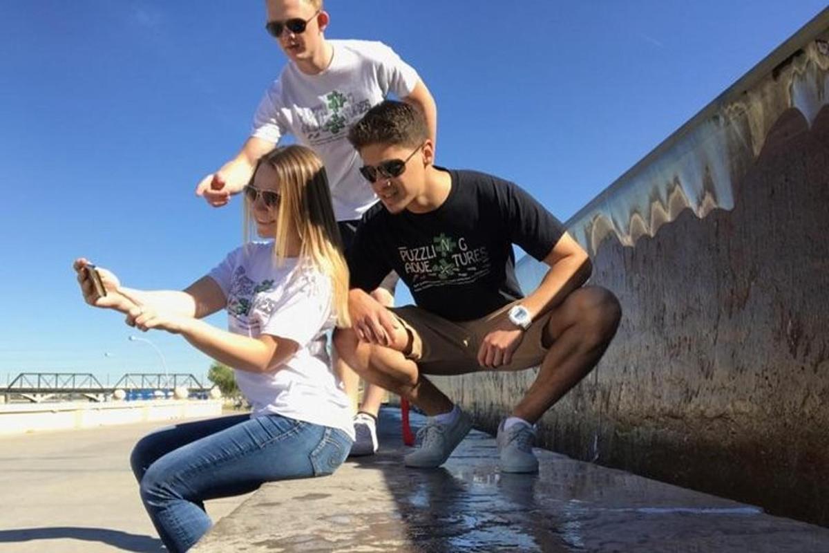 a group of people sitting on a wall near the beach