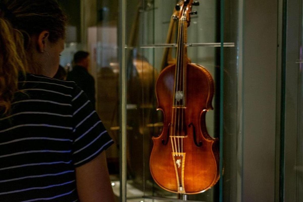 un uomo che guarda un violino in una vetrina