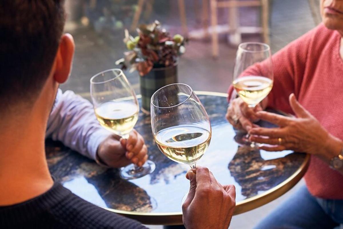 un gruppo di persone sedute attorno a un tavolo che bevono vino