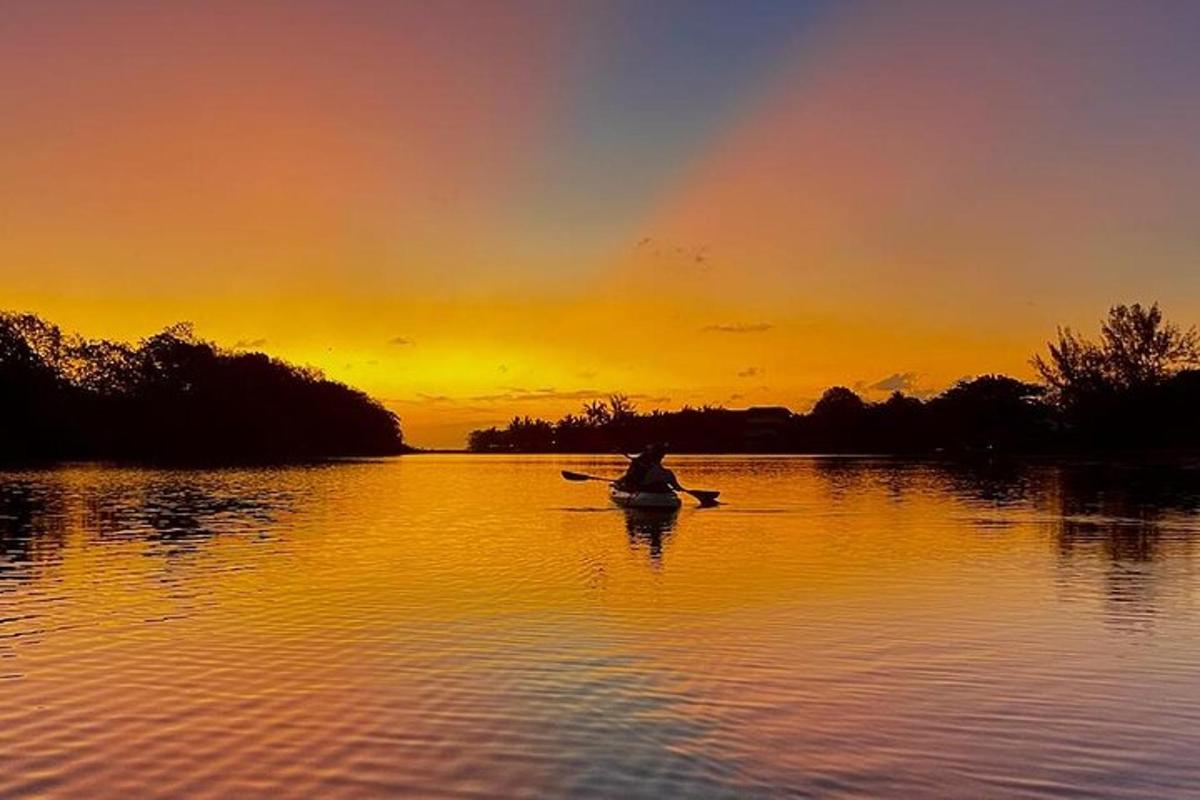 uma pessoa em um barco em um lago ao pôr do sol