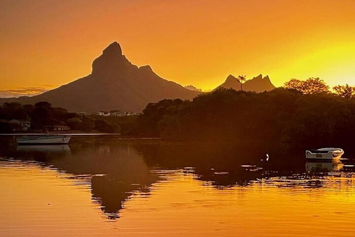 matahari terbenam di atas tasik dengan latar belakang gunung