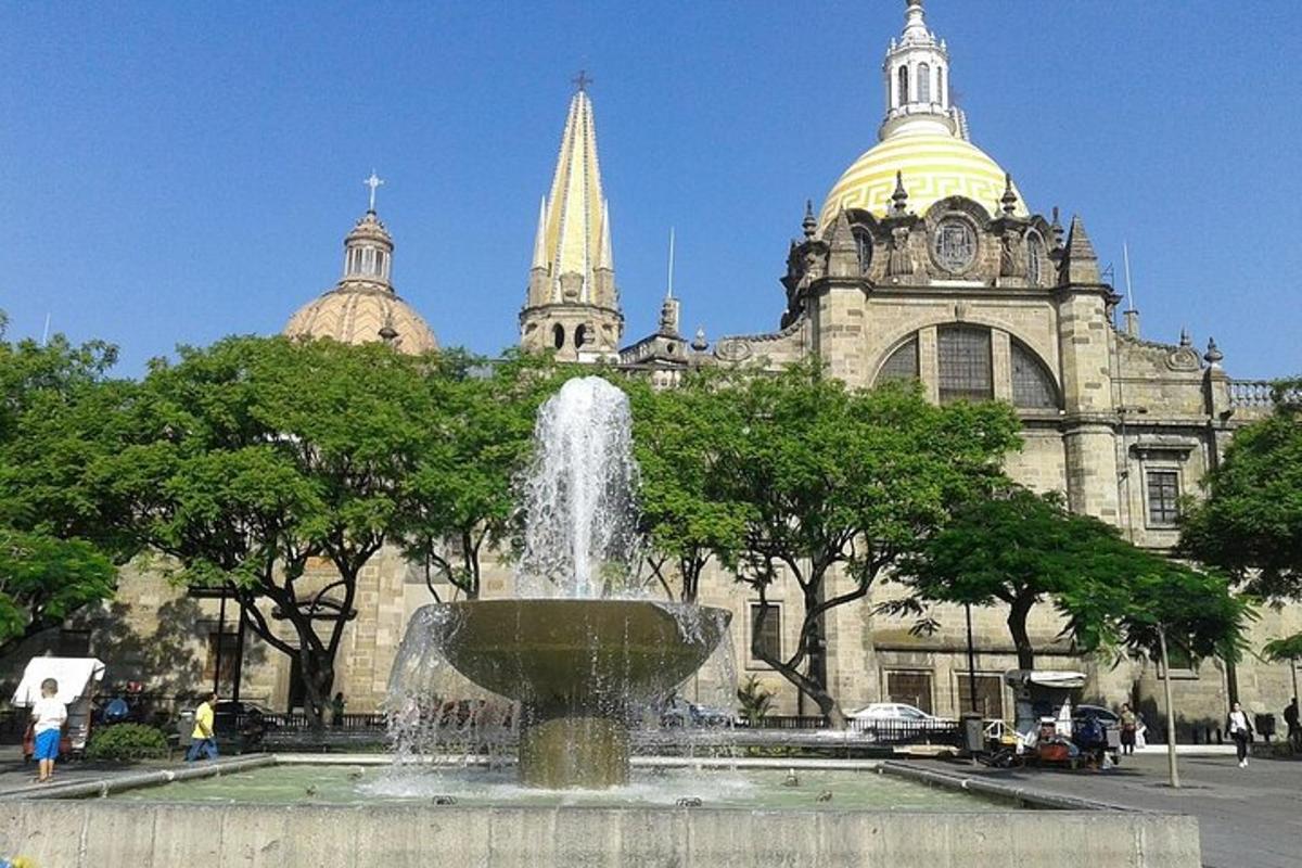 una fontana di fronte a un edificio con una torre dell'orologio