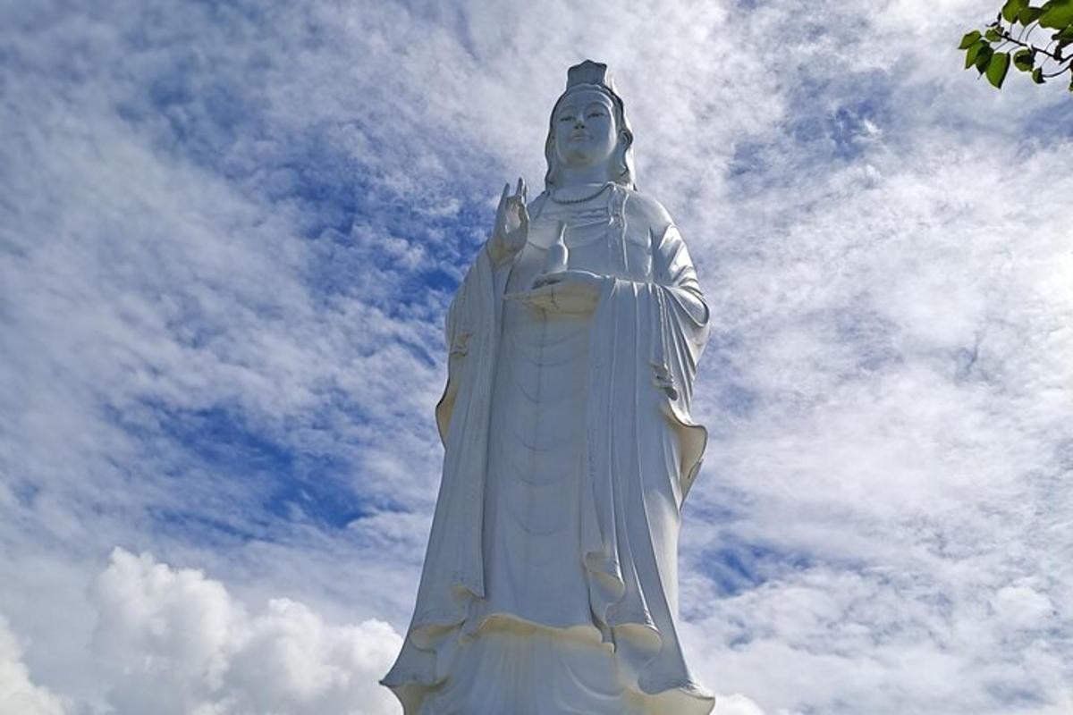 a large statue in front of a cloudy sky