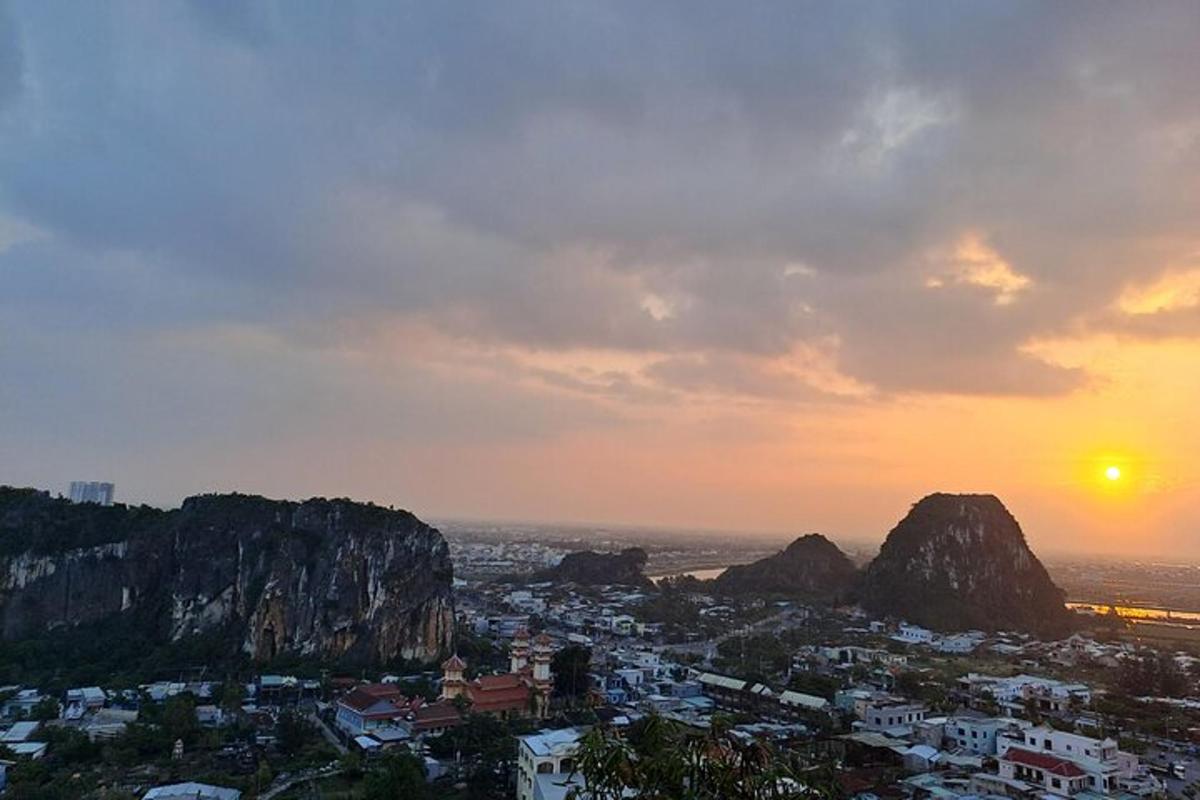 a view of a city with mountains and the sunset