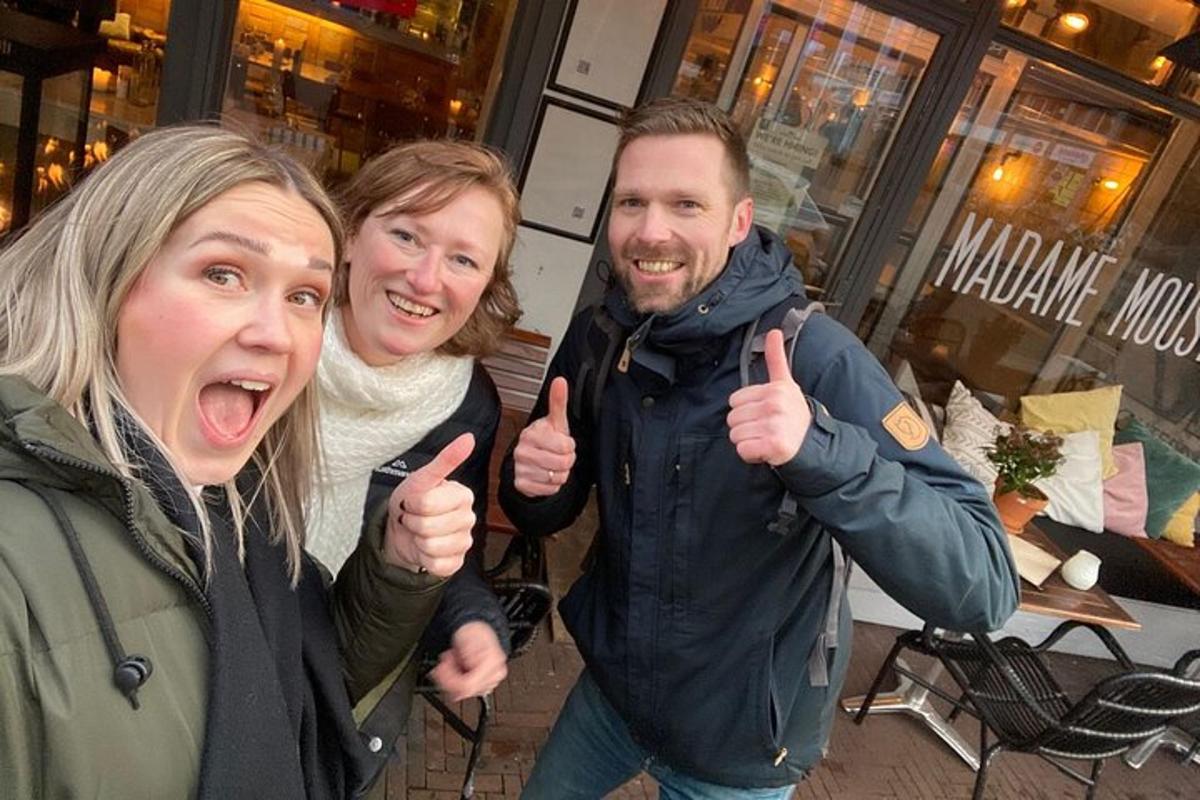 two women and a man giving thumbs up