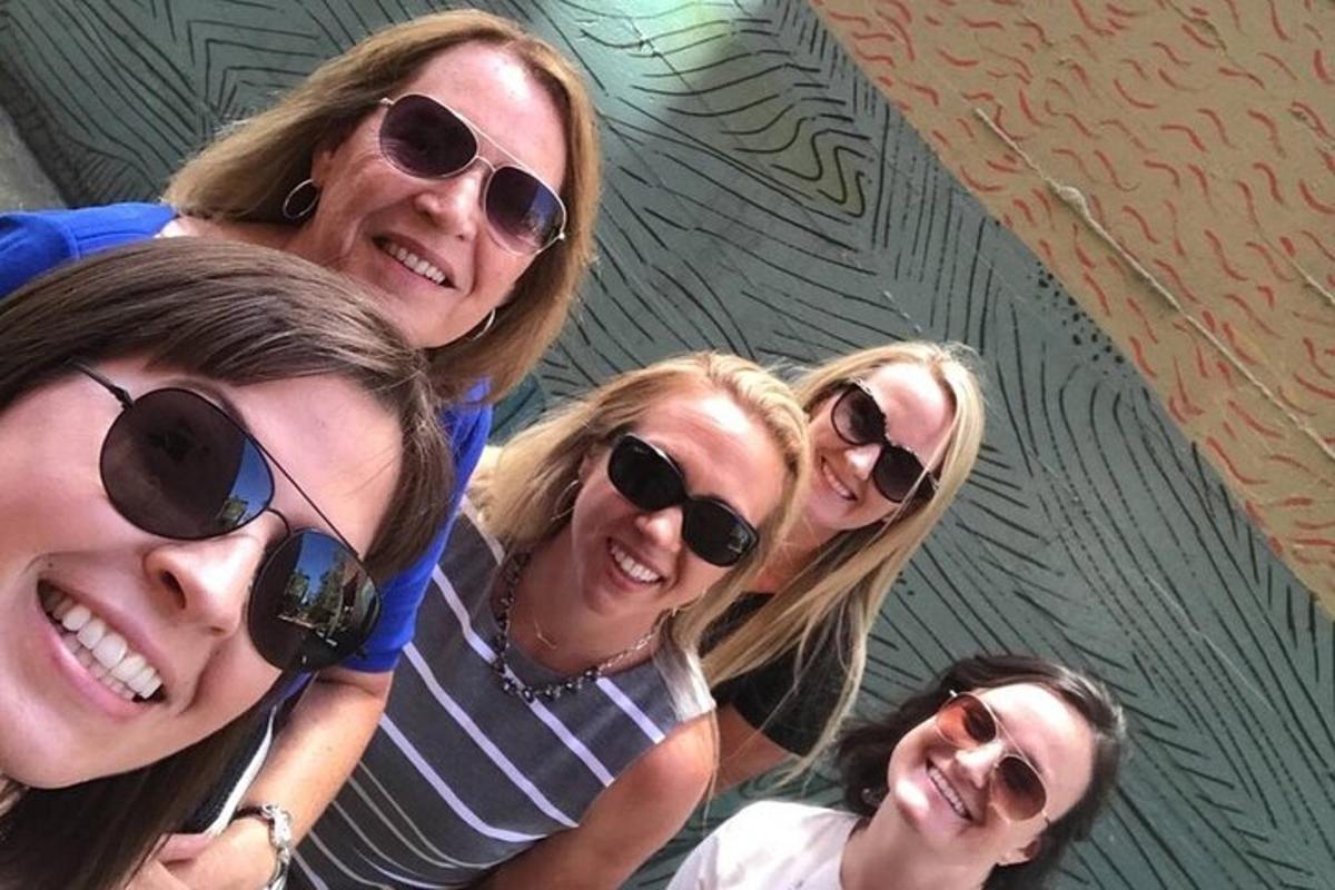 um grupo de mulheres usando óculos escuros posando para uma foto