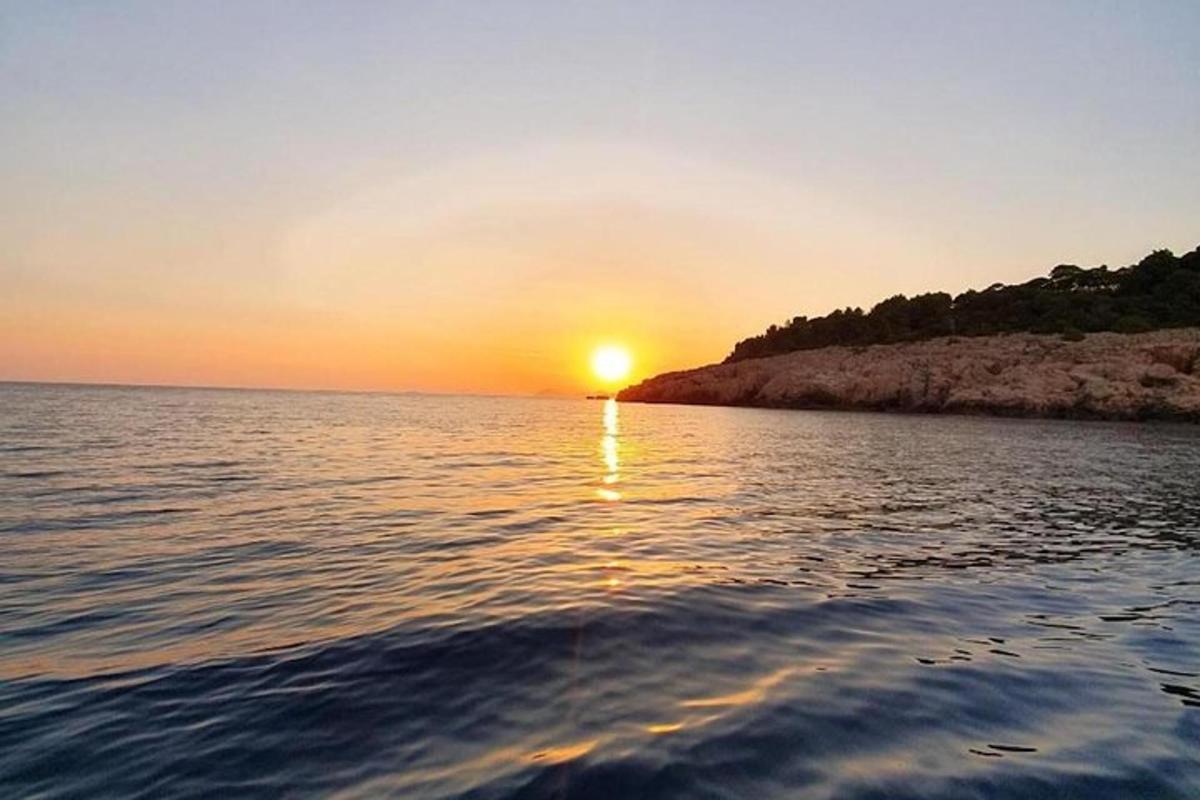 ένα ηλιοβασίλεμα πάνω από ένα υδάτινο σώμα με τη δύση του ηλίου