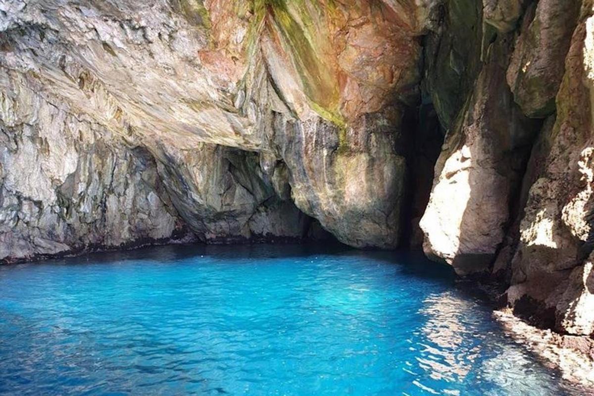 μια σπηλιά με γαλάζια νερά και έναν βραχώδη γκρεμό