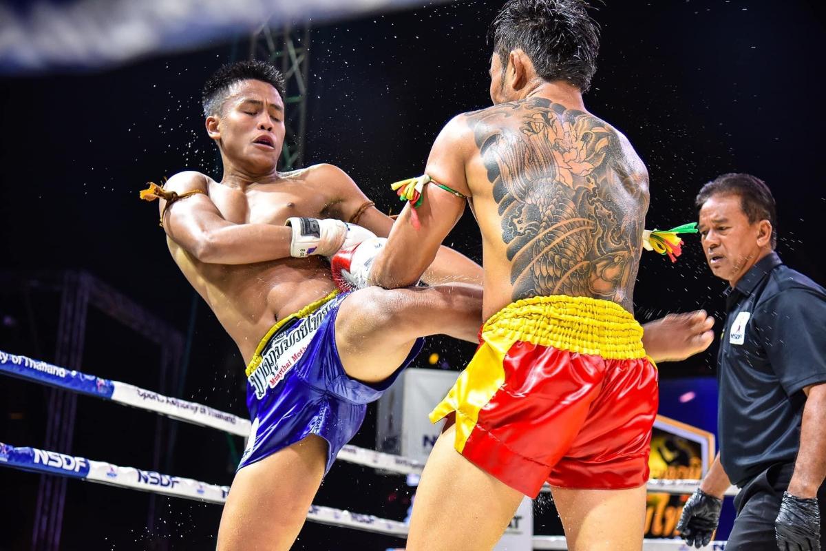 two men are fighting in a boxing match