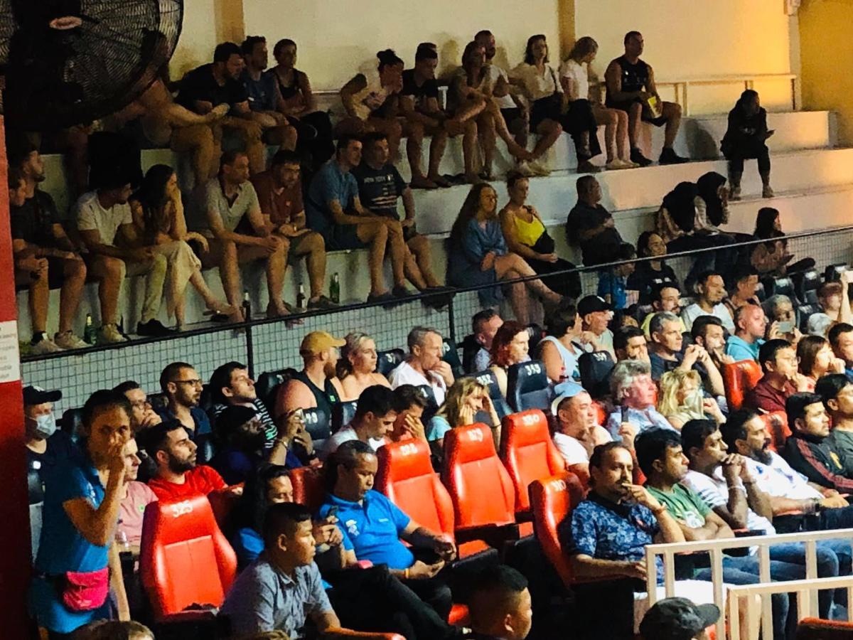a crowd of people sitting in an audience at a volleyball game