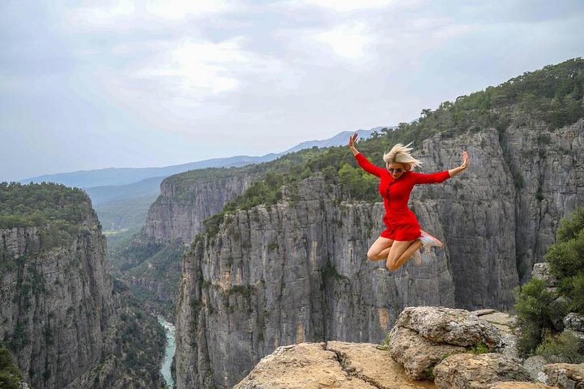 una donna che salta da una scogliera in un canyon