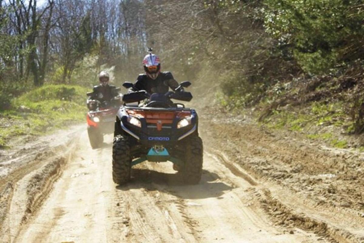 dues persones que viatgen en quads per un camí de terra