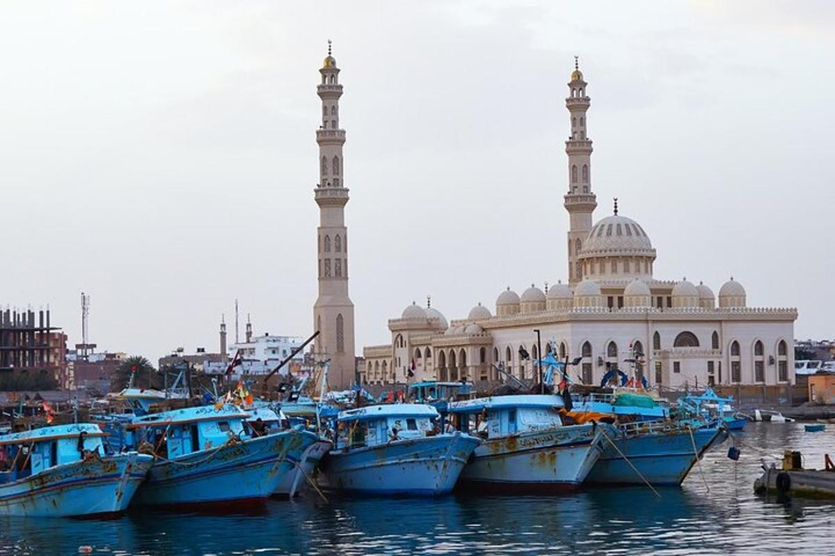 a group of boats in the water in front of a mosque