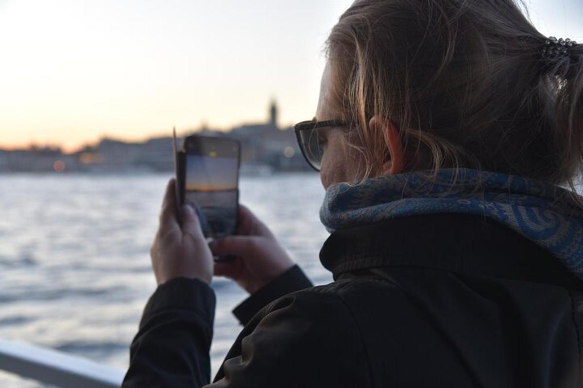 egy nő fényképezi a vizet a mobiltelefonjával