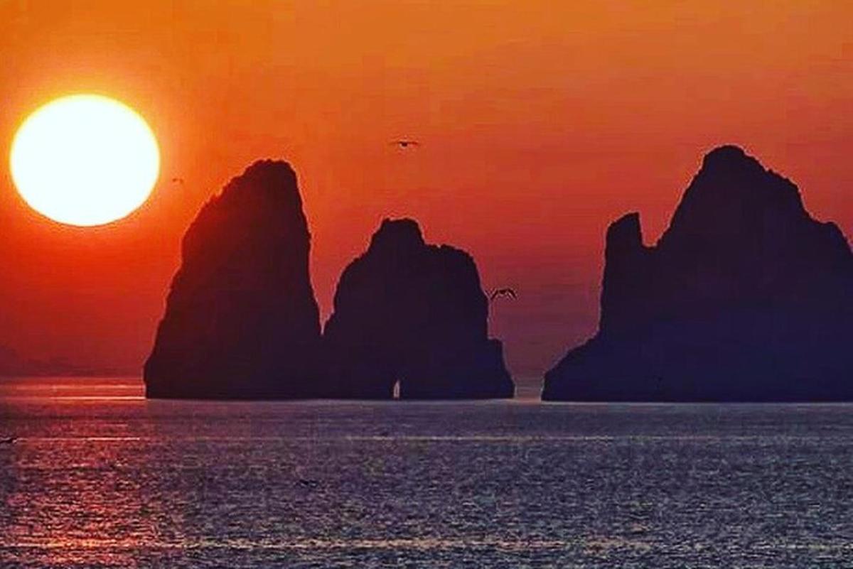 Ηλιοβασίλεμα πάνω από τον ωκεανό με βράχους στο νερό